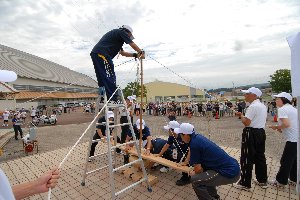 巨大なマイギリ（火おこし器）で火をおこす画像