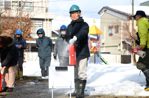 消火器操作訓練を行う男性の画像