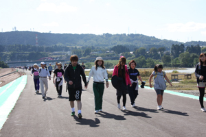 信濃川右岸堤防上を歩く参加者の画像