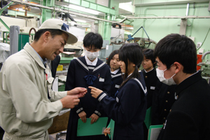 爪ほどの大きさの部品を確認する生徒たちの画像