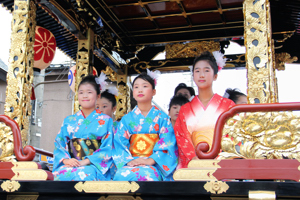 祭り屋台に乗る子どもたちの画像