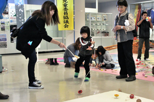 コマで遊ぶ子どもの画像