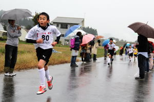 雨の中必死に走る選手の画像