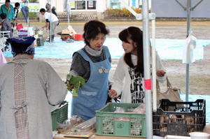 店頭で野菜を選ぶ来場者の画像