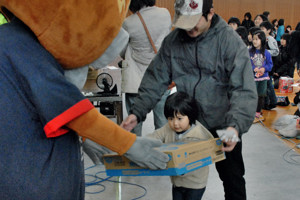 よし太くんから景品を受け取る子どもの画像