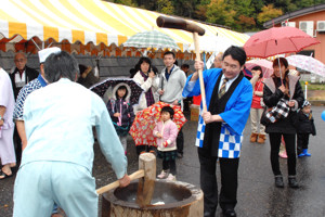 餅をつく係員の画像