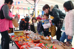 駄菓子屋さんでお菓子を選ぶ子どもたちの画像