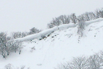 山の尾根から張り出した雪の画像