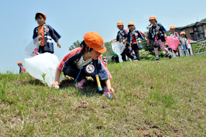 見つけたごみを拾う園児の画像