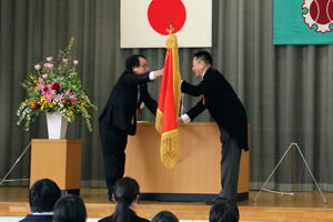 新しい校旗を授与される小川校長先生の画像