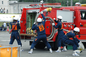 消防車からホースを外す消防隊員の画像