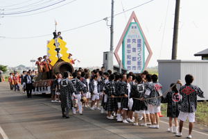 元気良く花火の筒を引く若者の画像