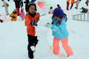 雪を積み上げる子どもたちの画像