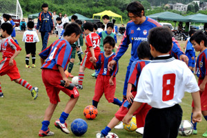 子どもたちに混ざってボールを蹴る村上選手の画像