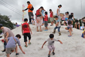 真夏の雪山で遊ぶ子どもたちの画像