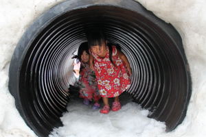 雪のトンネルを歩く子どもの画像