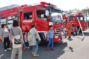 消防車に集まる子どもたちの画像