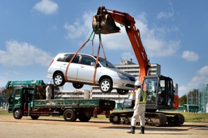 重機で車を持ち上げている画像