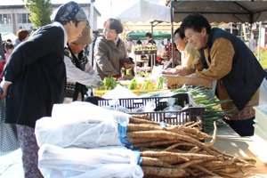 地場産野菜を買い求める来場者の画像