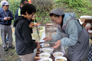 餅とけんちん汁を受け取る来場者の画像