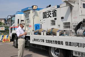 排水ポンプ車を見ながらメモを取る宮崎市長の画像