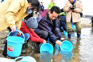 子どもたちと一緒にサケの稚魚放流をする宮崎市長の画像