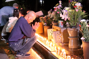 塩谷の慰霊碑の前で手を合わせる参列者の画像